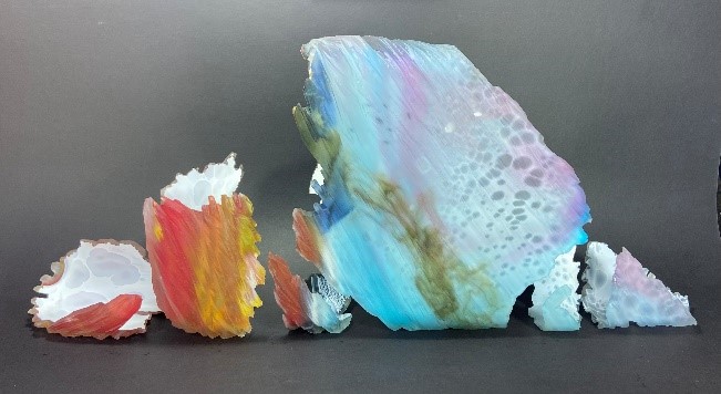 Pieces of broken glass grade from purples and blues to yellows and reds.