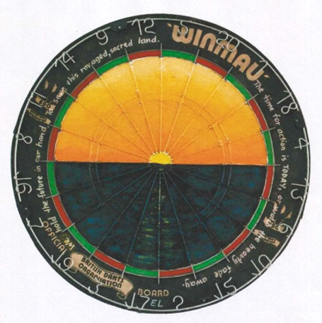 An old dartboard has had the centre painted over so the bullseye is now a sun rising over the ocean, resembling the sun in the Australian Aboriginal flag. Around the rim it reads The time for action is today, or watch the beauty fade away. We hold the future in our hand to save this ravaged, sacred land.